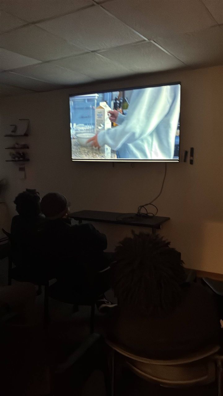 Audience watching a short film in the dimmed room.